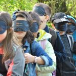 kids all are standing in line and wear a eye mask