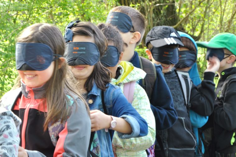 kids all are standing in line and wear a eye mask