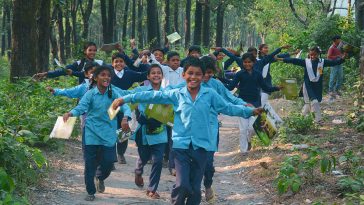 A group of kids running in the meddle of the forest